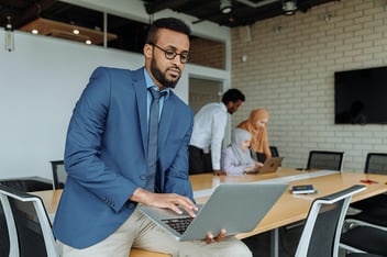 Man in Blue Suit Jacket Using a Laptop
