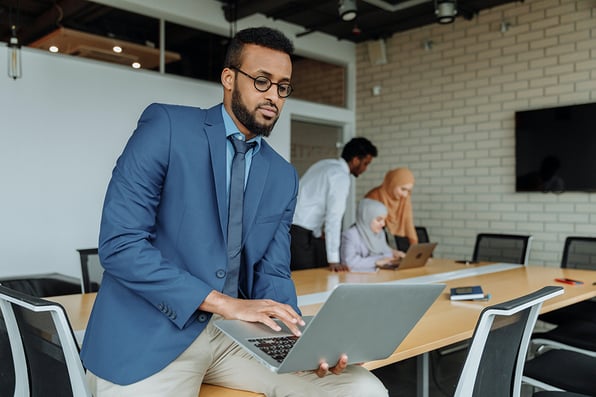Man in Blue Suit Jacket Using a Laptop