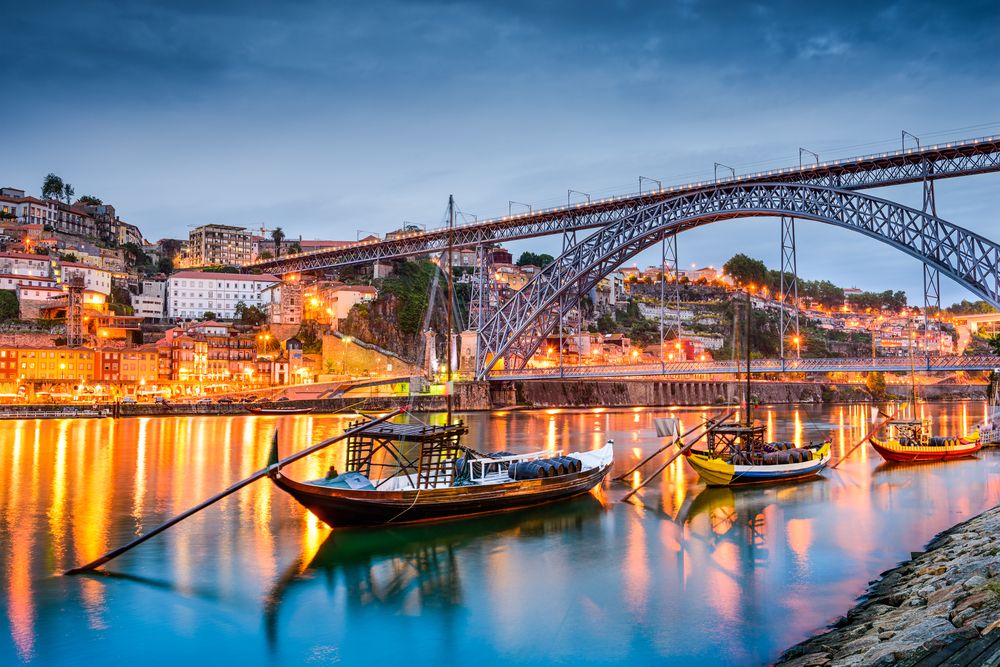 Porto, Portugal old town skyline on the Douro River with rabelo boats.