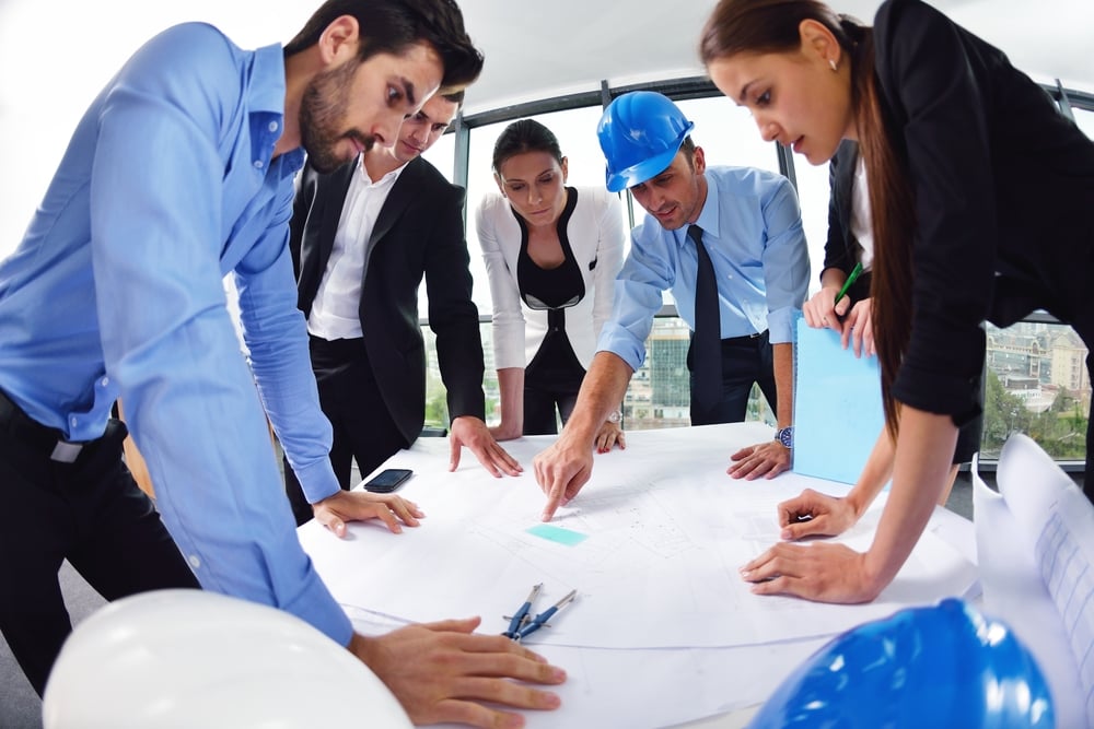 business people group on meeting and presentation  in bright modern office with construction engineer architect and worker looking building model and blueprint planbleprint plans-1