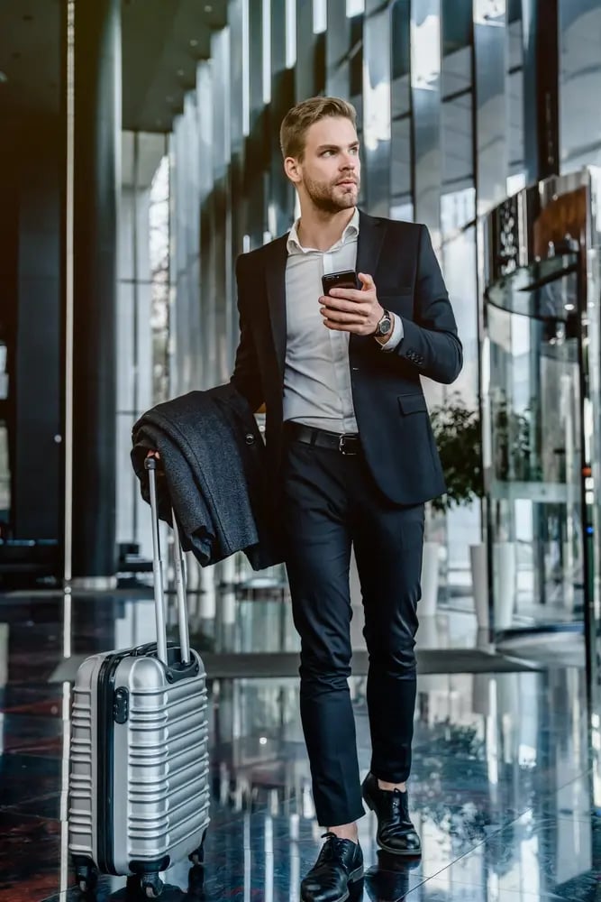 vertical-shot-young-businessman-walking-with-suitcase-airport